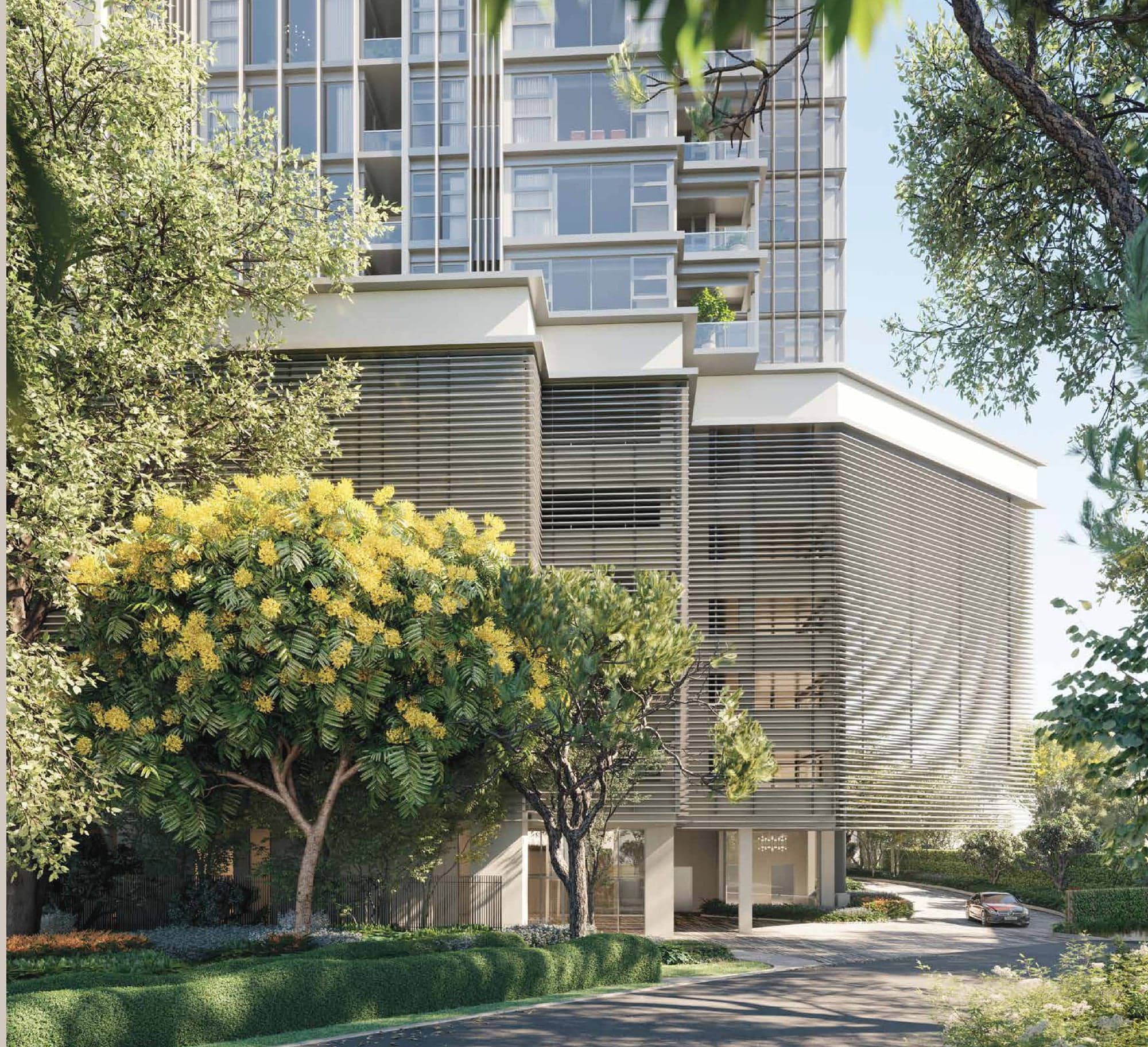 The arrival frontage at 111 Menerung — the tower rising behind a battened podium, with a flowering tree over the drop-off and the driveway curving in from Jalan Menerung