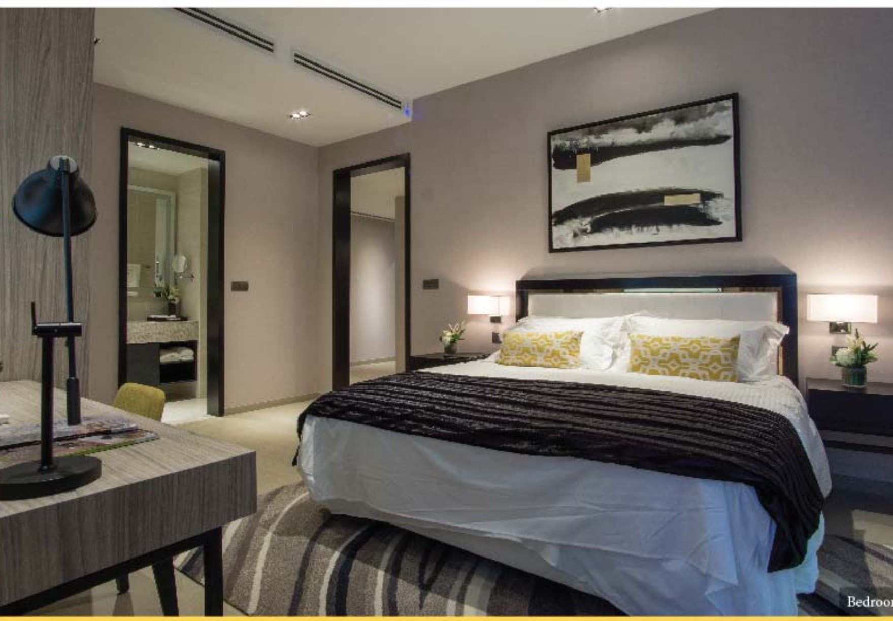 Ascott Star Residence furnished bedroom — upholstered headboard, twin wall sconces, a work desk and the marble-lined bathroom beyond, the actual handover interior