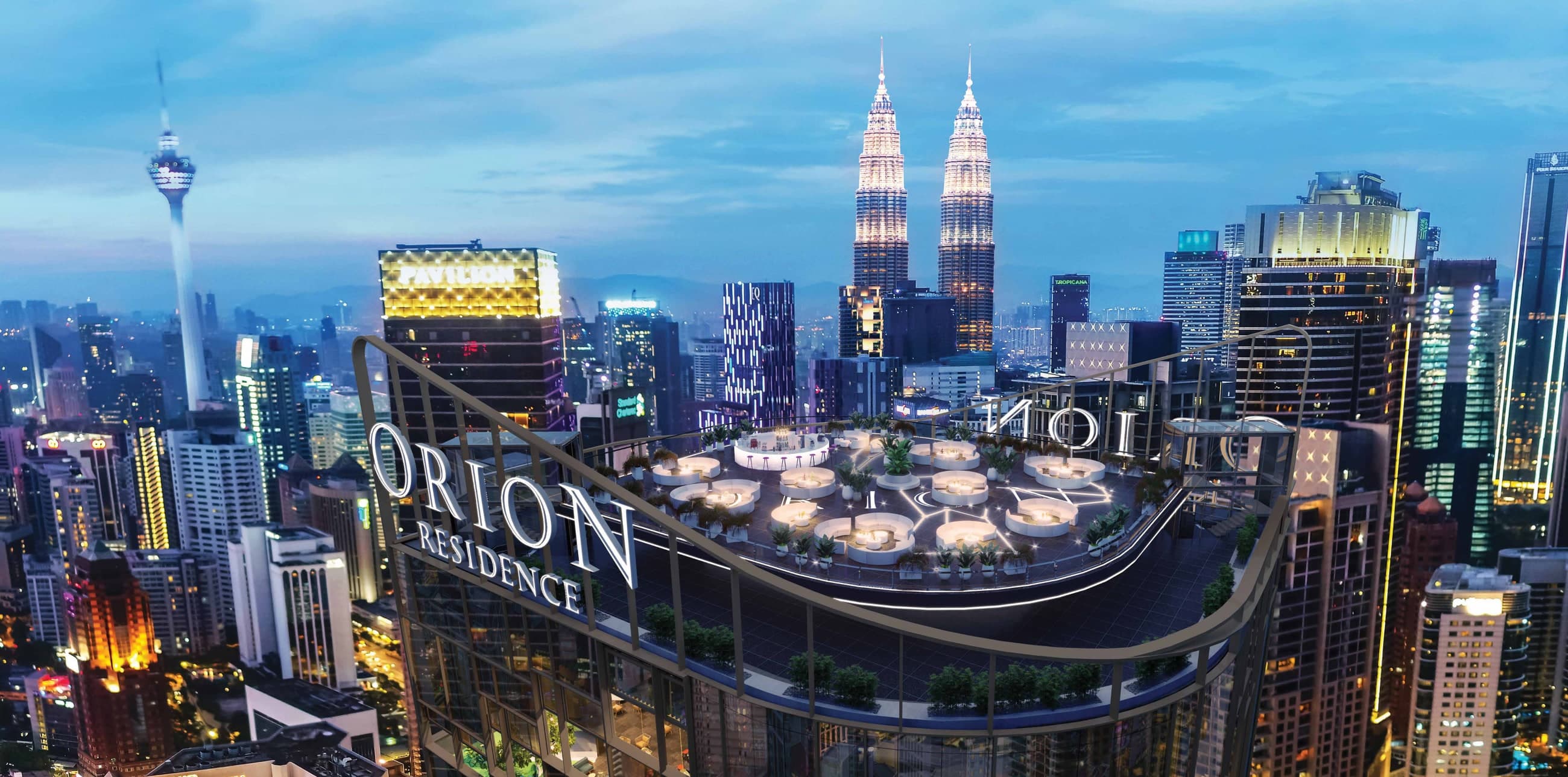 Orion Residence from above at dusk — the illuminated Orion Residence crown and rooftop deck in the foreground with the Petronas Twin Towers, Pavilion Kuala Lumpur and KL Tower across the Bukit Bintang skyline behind