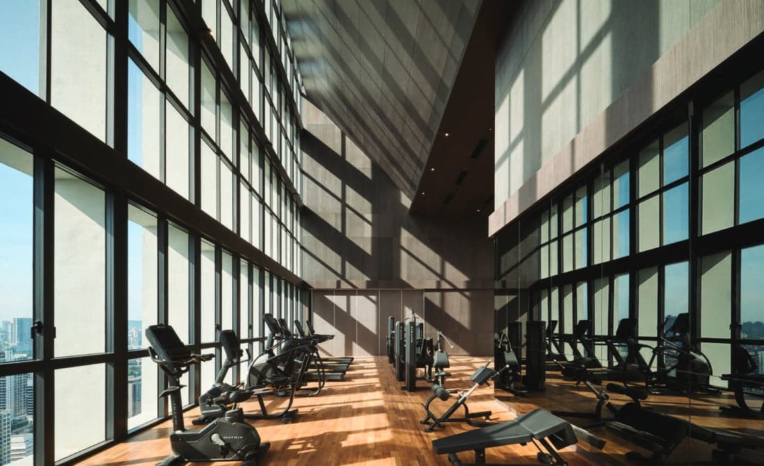The gymnasium — a double-height room glazed on both long sides, high above the city