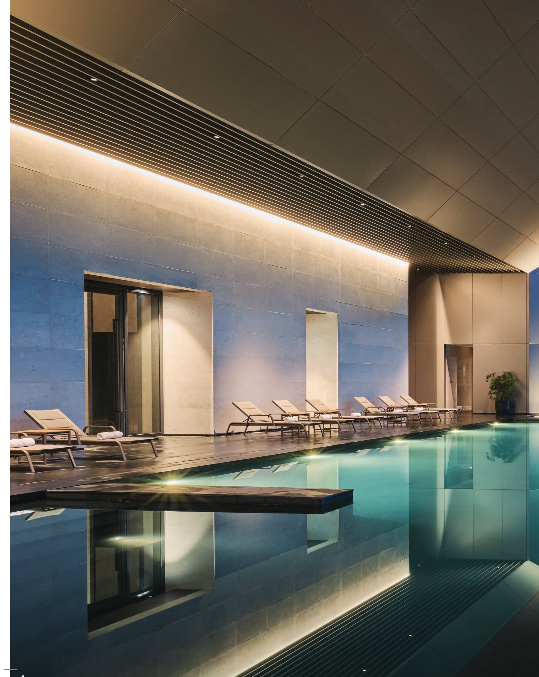 The heated swimming pool — a lap pool under stone and warm light; both facility floors carry one