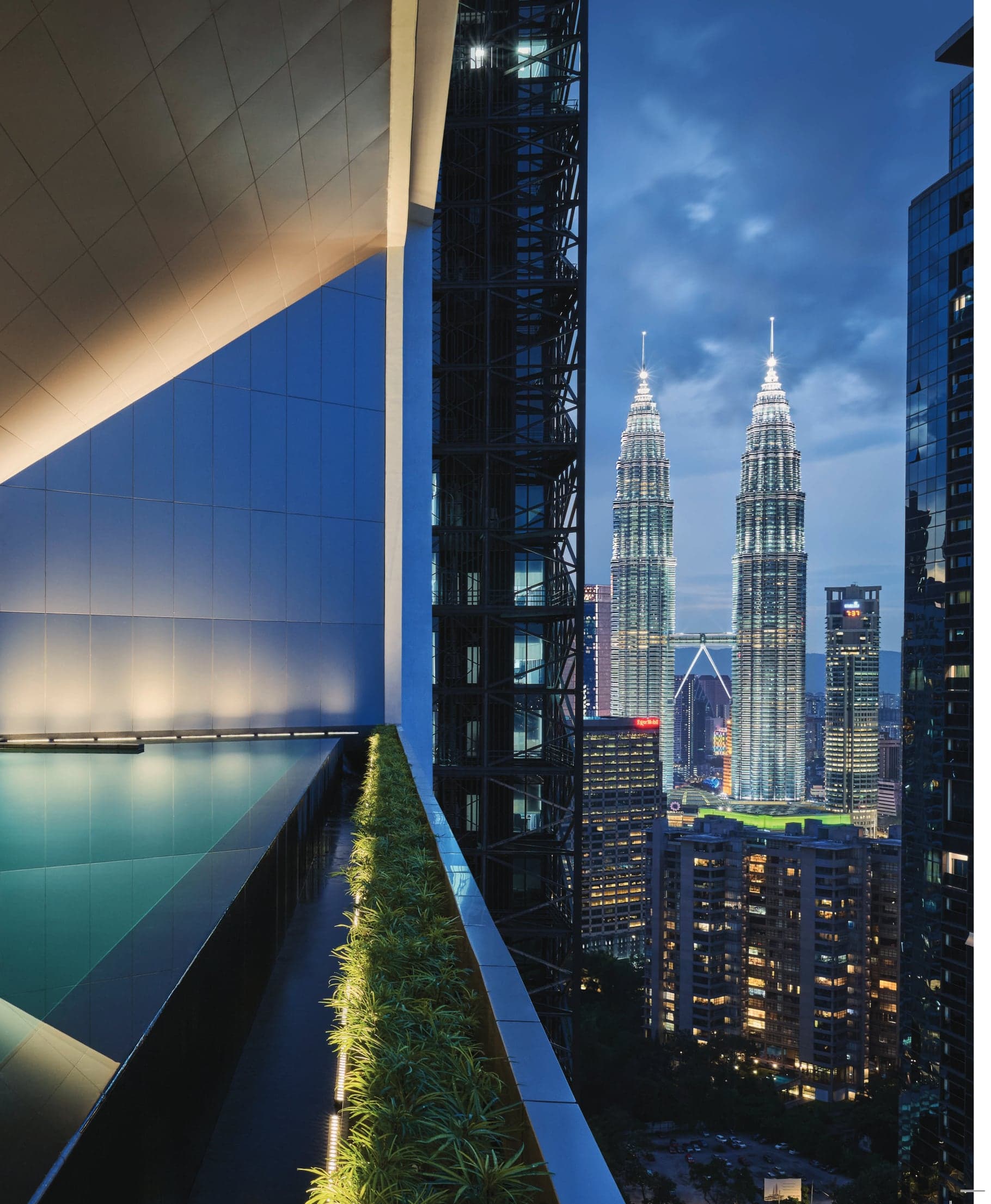 The pool edge, planted with greenery, looking straight at the Petronas Twin Towers
