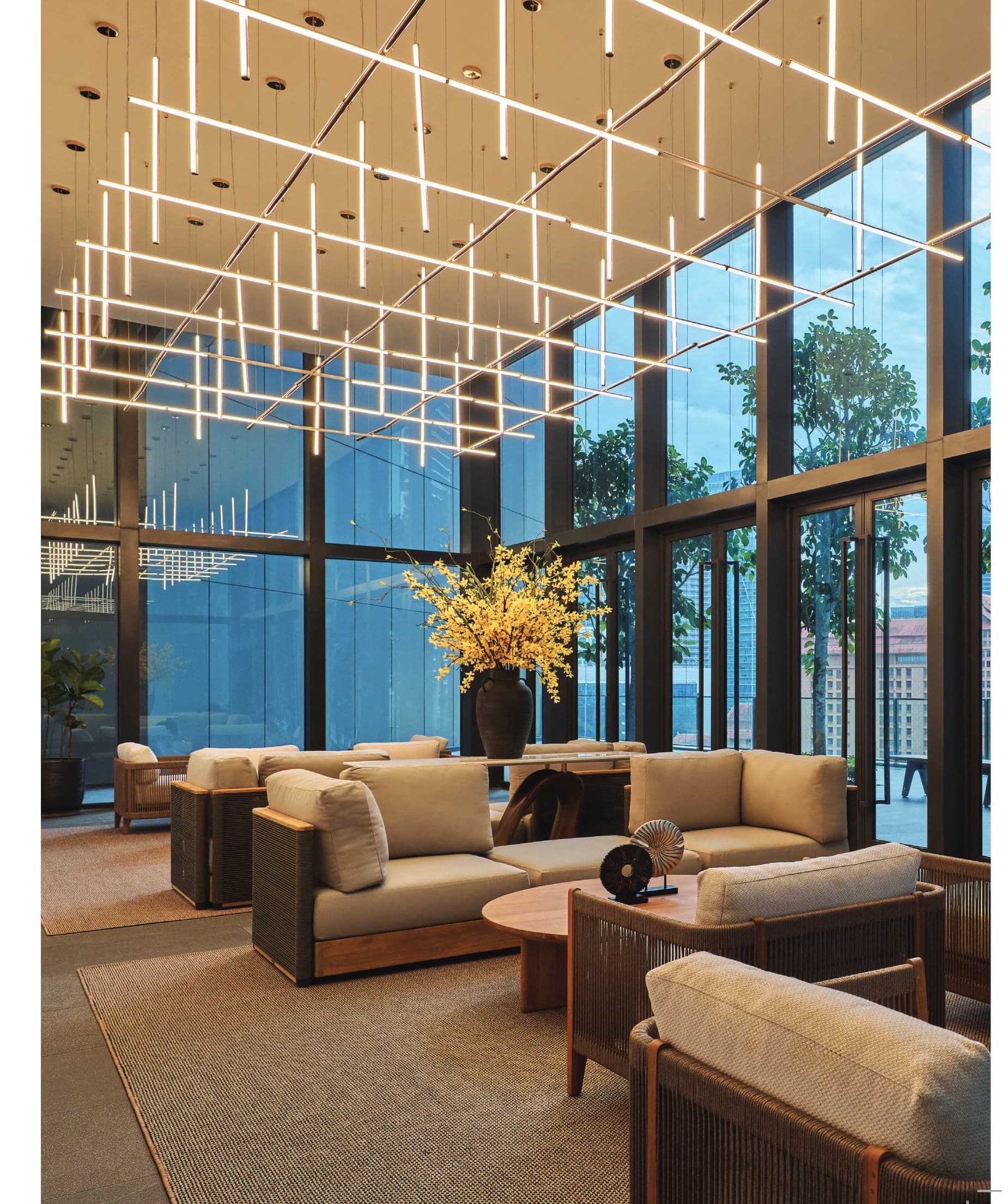 The sky lounge — full-height glass, linear pendant lighting and the city beyond, on the upper facility floor
