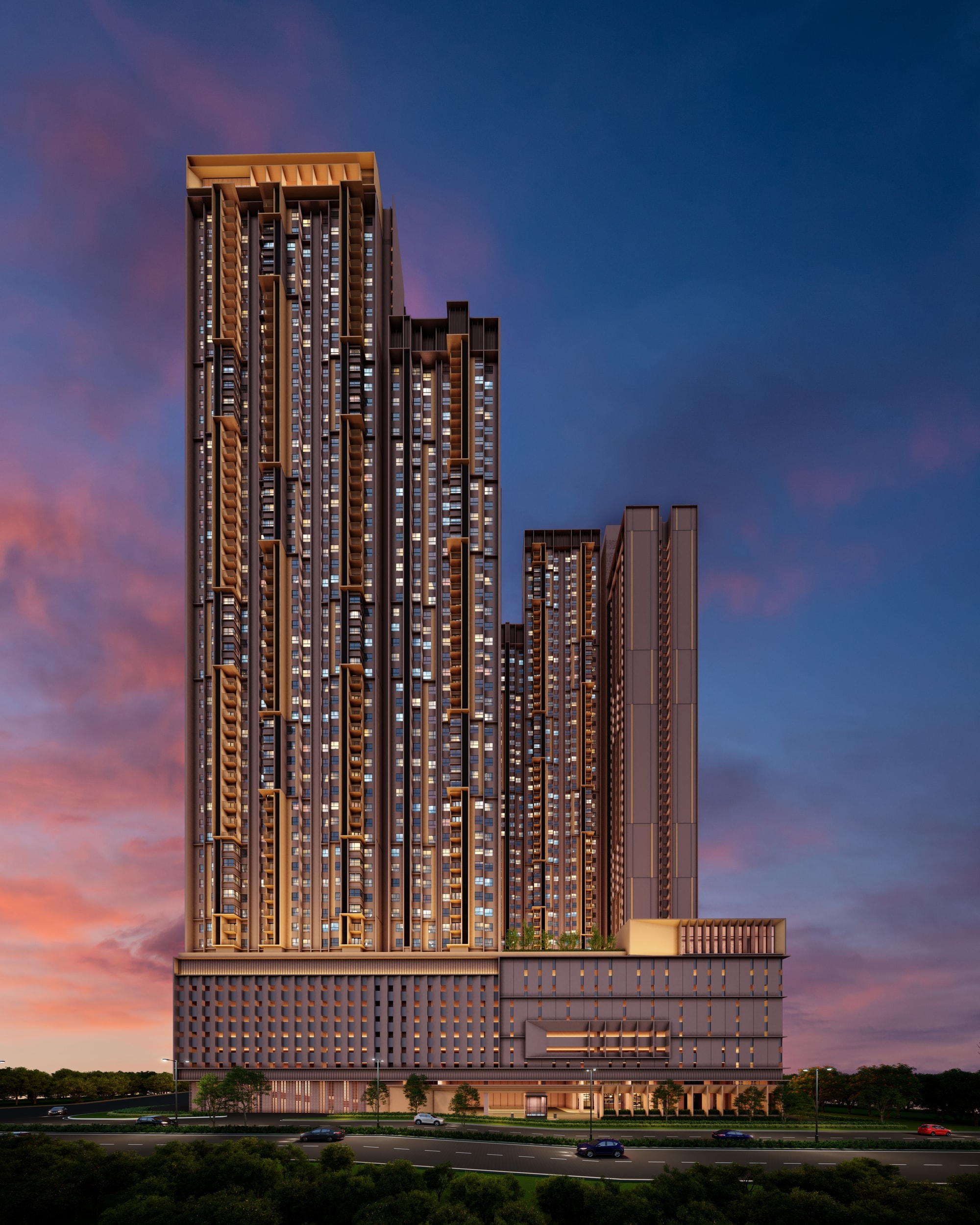 The Vividz @ Bukit Jalil at dusk — two residential towers stepping down from left to right above a lit podium, seen from the road